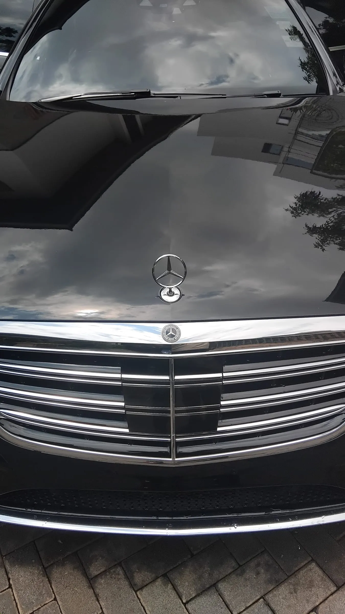 The same Mercedes-Benz S-Class after paint protection film, the black bonnet mirror-finished and reflecting the sky